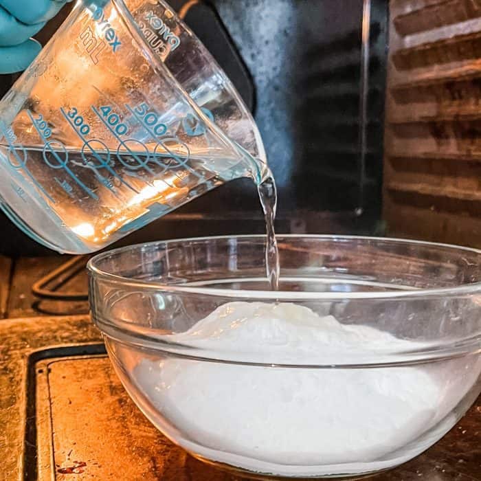 adding hot water to make cleaning paste