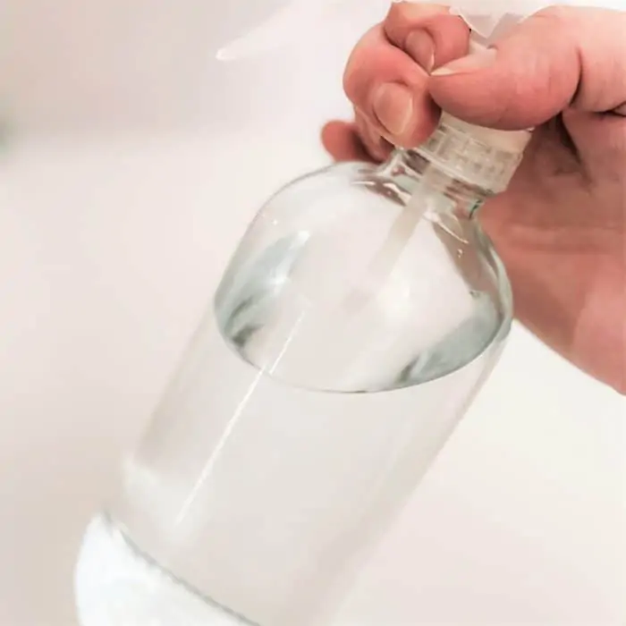 swirling water and baking soda mixture in spray bottle