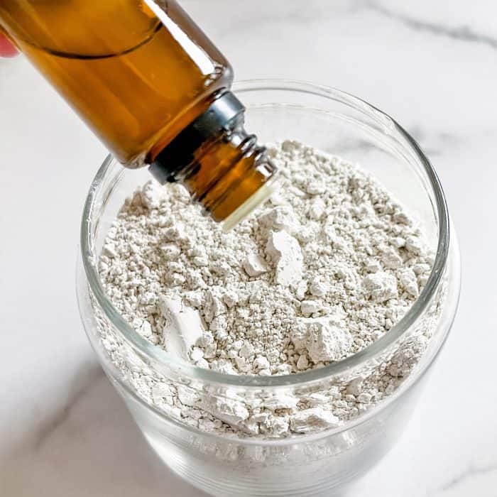 adding essential oil to glass jar to make homemade deodorizer