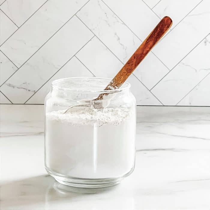 using wooden spoon to stir ingredients for homemade refrigerator freshener