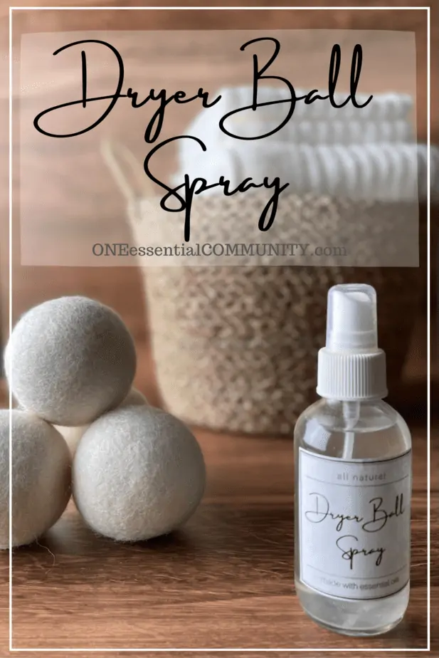 DIY Dryer Ball Spray by oneessentialcommunity.com -- glass spray bottle with free printable label next to 3 dryer balls and laundry basket