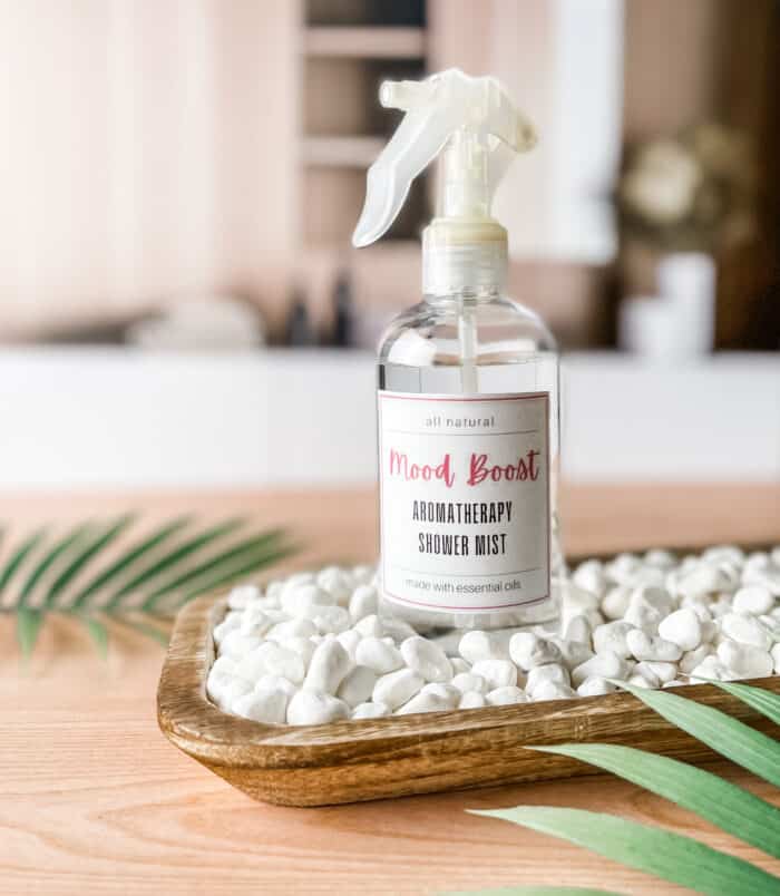 mood boost aromatherapy shower mist on wooden tray on spa counter