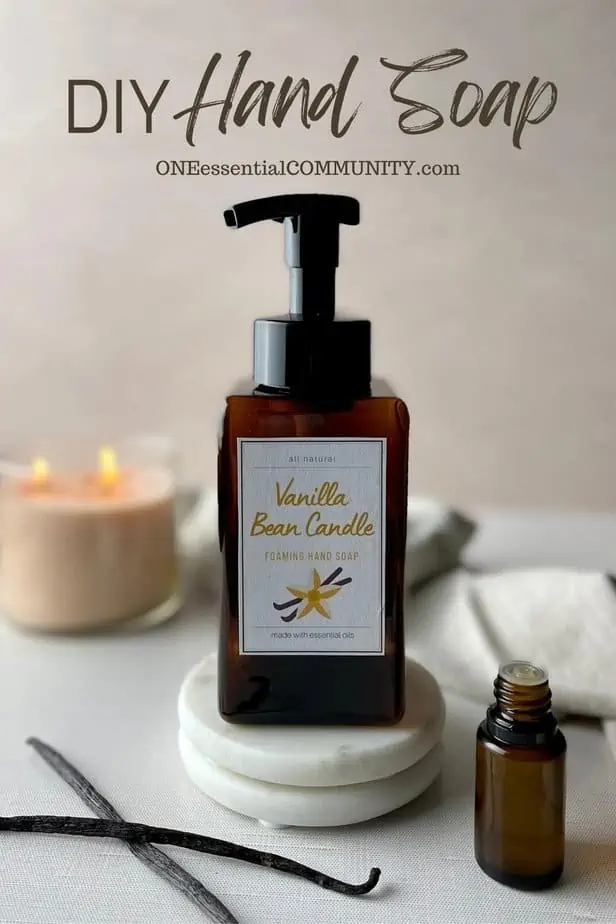 DIY Hand Soap by oneessentialcommunity.com -- vanilla bean candle scented hand soap with lit vanilla candle, vanilla beans, essential oil bottle, and vanilla-colored towel