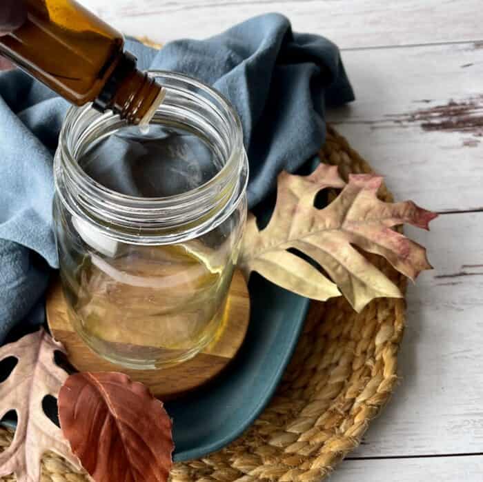 adding essential oil to mason jar