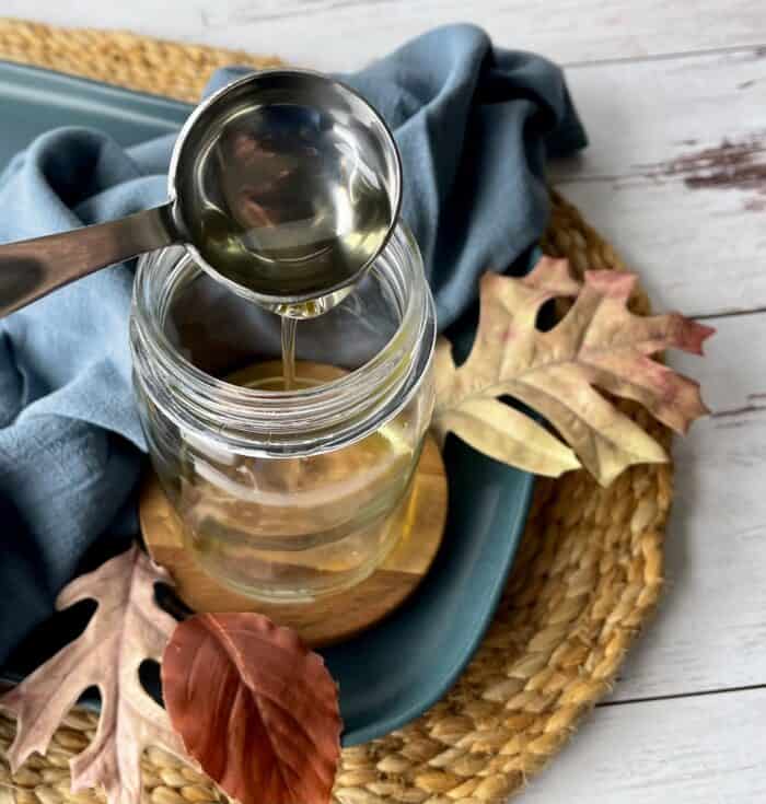 adding apricot kernel oil to mason jar