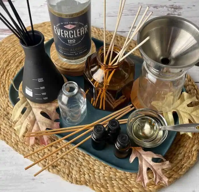 supplies for making your own reed diffuser- essential oils, Everclear, apricot kernel oil, mason jar, funnel, reed diffuser sticks, and narrow opening glass vases