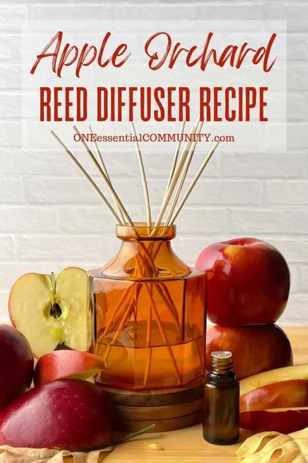 apple orchard reed diffuser recipe by oneessentialcommunity.com -- essential oil bottle, apples and apple slice around amber glass reed diffuser