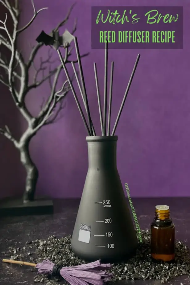 witch's brew reed diffuser recipe by oneessentialcommunity.com -- essential oil bottle, mini purple witch's broom, and black haunted tree around black flask for homemade reed diffuser