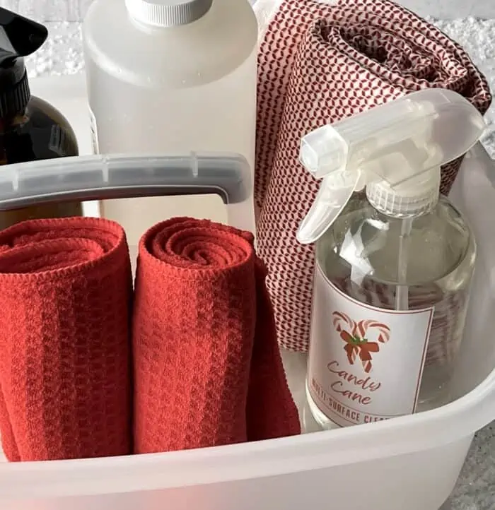 cleaning caddy with Candy Cane-scented cleaning spray, 2 red cleaning clothes, red & white towel, soap, and amber spray bottle