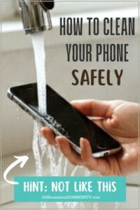 How to Clean your phone safely by OneEssentialCommunity.com (Hint: not llke this) woman's hand holding cell phone under running water from kitchen sink faucet